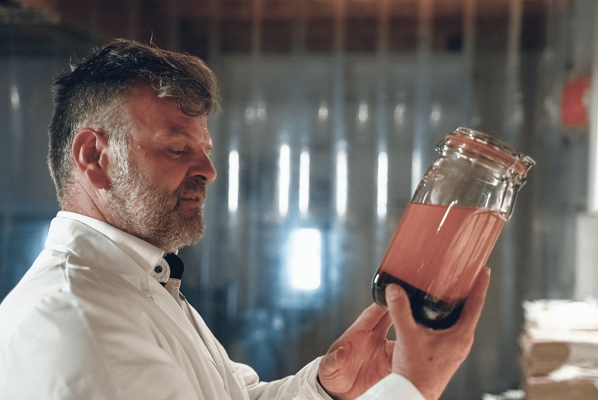 Jerome Janin, founder of Polyextract.com looking at mushroom extract in a glass jar