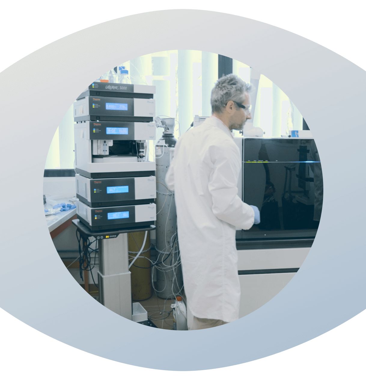 Person in a lab coat working with HPLC laboratory equipment in a lab setting